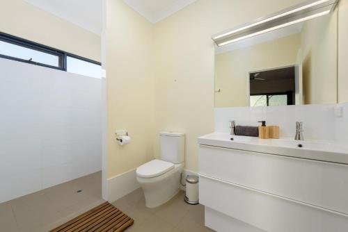 a white bathroom with a toilet and a sink at 120 Madaffari Drive in Exmouth