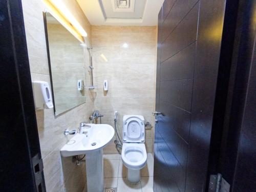 La salle de bains est pourvue de toilettes, d'un lavabo et d'un miroir. dans l'établissement Abu Hail Star Residence - Home Stay, à Dubaï