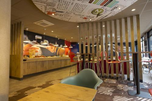 a restaurant with tables and chairs and a counter at ibis Lille Centre Grand Palais in Lille