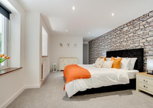 a bedroom with a large bed and a brick wall at High Trees in Carmarthen