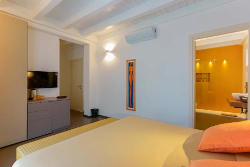 a white bedroom with a bed and a television at B&B Hole6 in Castenaso