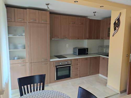 a kitchen with wooden cabinets and a microwave at Апартамент Родопи in Smolyan