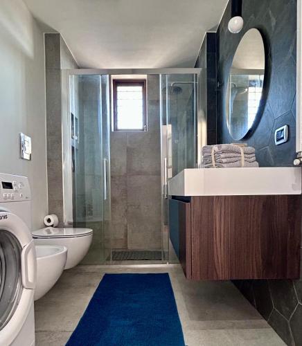 a bathroom with a shower and a sink and a washing machine at ISOLA ROVI in Santo Spirito