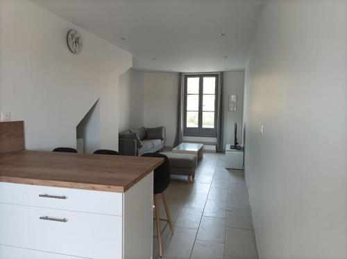 a kitchen and living room with a couch and a table at La petite Jarlandine in Château-Arnoux-Saint-Auban