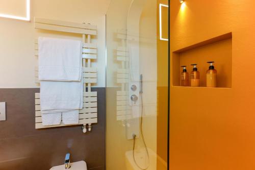 a bathroom with a shower and a toilet and towels at B&B Hole6 in Castenaso