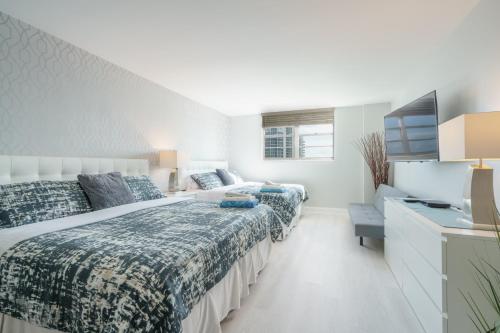 a bedroom with two beds and a tv at OCEAN RESERVE - 15th Floor - Gorgeous Ocean View in Miami Beach