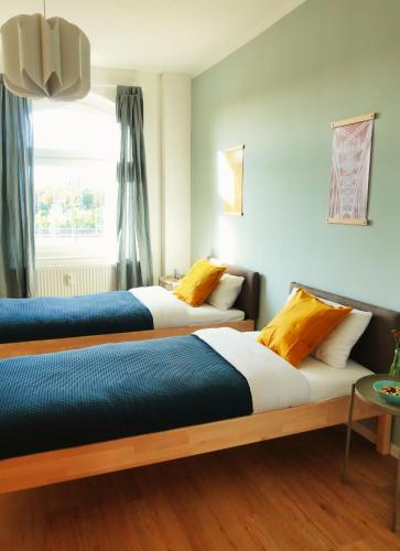 dwa łóżka siedzące obok siebie w pokoju w obiekcie Luvono Apartments - 2 Schlafzimmer / Netflix / Disney+ w mieście Magdeburg