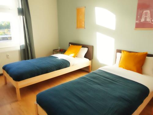 dwa łóżka siedzące w pokoju z w obiekcie Luvono Apartments - 2 Schlafzimmer / Netflix / Disney+ w mieście Magdeburg