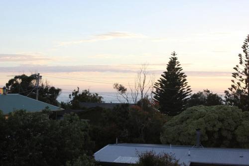 Blick auf eine Stadt mit Bäumen und Sonnenuntergang in der Unterkunft Apollo Bay Oceanview Mountain Retreat, Pet Friendly, EV station, Fireplace in Apollo Bay