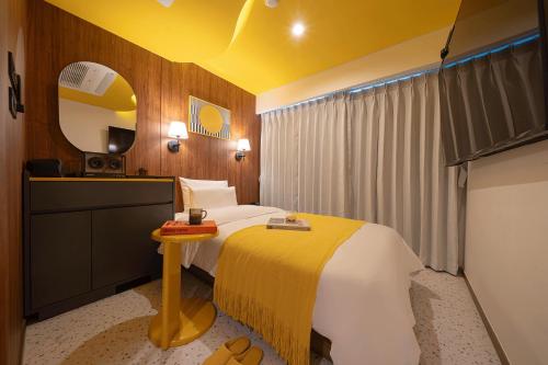 Habitación de hotel con cama y espejo en Nouvelle Hotel Seoul Itaewon en Seúl