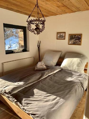 a large bed in a bedroom with a chandelier at Schönbacher Hof in Hopfgarten im Brixental