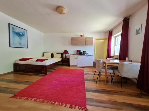 sala de estar con cama y alfombra roja en Ferienwohnungen-Allerheiligen-Wasserfälle, en Oppenau