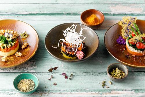 a group of plates with food on a table at ROBINSON MALDIVES - Adults only in Gaafu Alifu Atoll