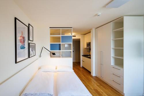 1 dormitorio con cama y armario en SMARTments business Wien Heiligenstadt en Viena