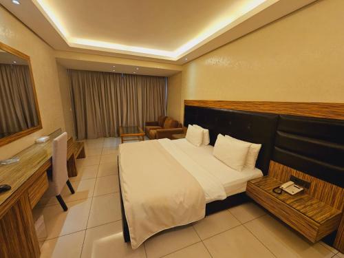 Habitación de hotel con cama grande y sofá en Verdun Suites Hotel, en Beirut