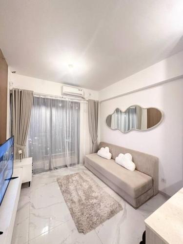 a living room with a couch and a television at Apartement 2BR sky house BSD in Cilenggang