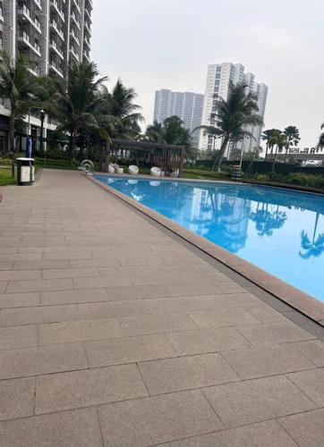 a large swimming pool in a city with tall buildings at Apartement 2BR sky house BSD in Cilenggang