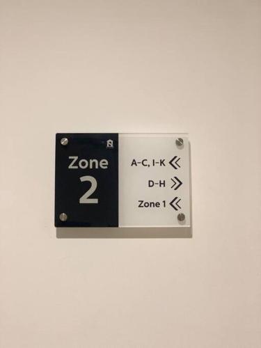 a black and white clock on a white wall at Apartement 2BR sky house BSD in Cilenggang