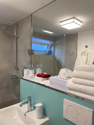 a bathroom with a sink and a mirror with towels at SIR WALTER Work & Stay, HOMEOFFICE, W-LAN in Neuss
