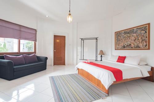 a bedroom with a large bed and a couch at RedDoorz Plus near Dago Pakar in Bandung