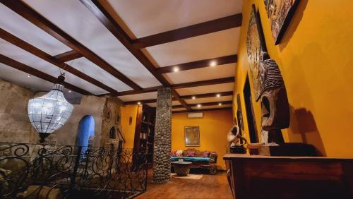 a living room with yellow walls and a ceiling at Avalon Ubud Castle & SPA in Ubud