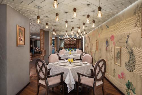 a dining room with a table and chairs and lights at WOW Crest, Indore - IHCL SeleQtions in Indore