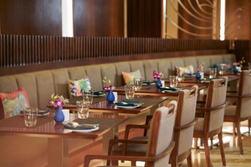 a row of tables and chairs in a restaurant at WOW Crest, Indore - IHCL SeleQtions in Indore