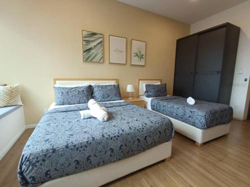 a bedroom with two beds with blue and white sheets at Ceylonz Suites, casa for your holiday in Kuala Lumpur