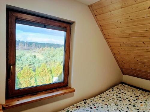 - une chambre dotée d'une fenêtre avec un lit et une vue dans l'établissement Yellow House, à Wąglikowice