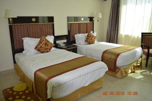 a hotel room with two beds in a room at Tiffany Diamond Hotels - Mtwara in Mtwara