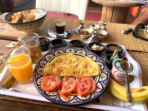 un piatto per la colazione con una frittata e pomodori su un tavolo di Mabidi Surf Taghazout a Taghazout