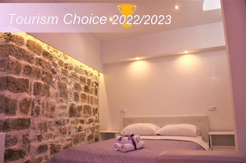 Pokój z łóżkiem i ceglaną ścianą w obiekcie Medulić Palace Rooms & Apartments w Szybeniku