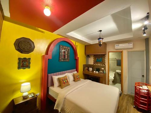 ein Schlafzimmer mit einem Bett in einem farbenfrohen Zimmer in der Unterkunft Rain Airport Bed and Breakfast in Manila