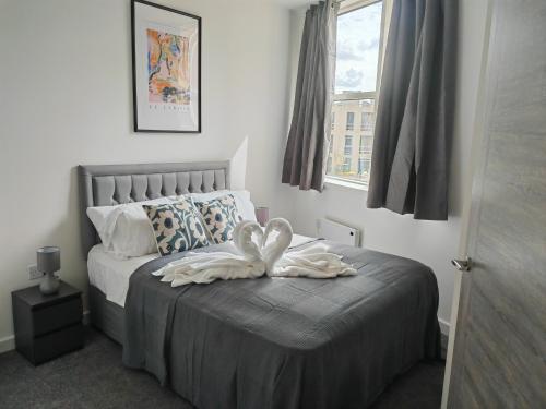 um quarto com uma cama com duas toalhas em Modern Two Bedroom Apartment - Central Peterborough em Peterborough
