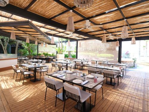 - un restaurant avec des tables et des chaises dans une salle dans l'établissement Kuum Hotel & Spa, à Türkbükü