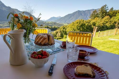 a table with a piece of cake and a bowl of fruit at Feldhasen in Bad Ischl