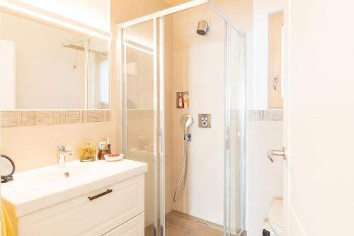 a white bathroom with a shower and a sink at Feldhasen in Bad Ischl