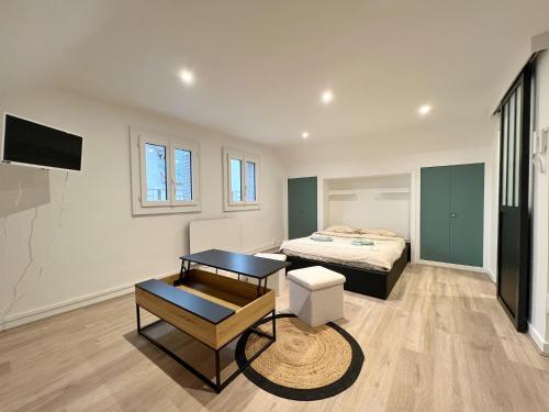 Studio Prés Riants في إيكس لي بان: غرفة نوم فيها سرير وطاولة فيها