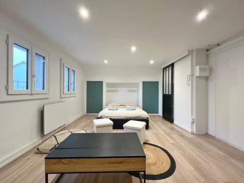 a room with two beds and a table in it at Studio Prés Riants in Aix-les-Bains