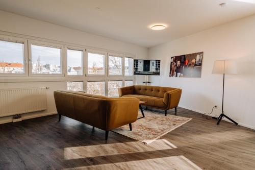 sala de estar con sofá, sillas y ventanas en URBAN ISLAND I Riverside Apartments, en Viena