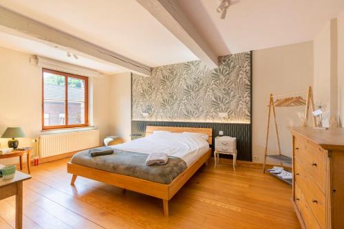 a bedroom with a large bed in a room at Côté cour, côté source chambre d'hôtes in Chaudfontaine