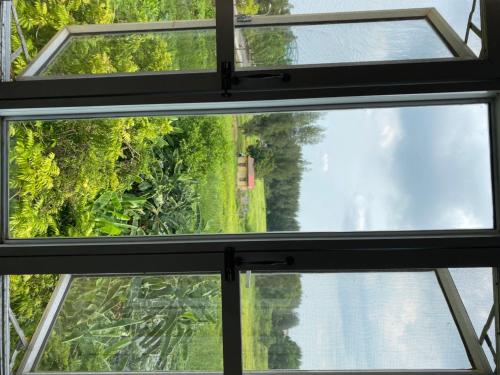 una ventana abierta con vistas a un bosque en Khách sạn Phương Đông, en Hải Dương