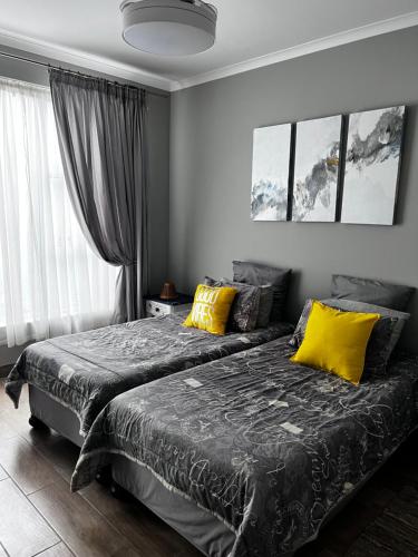 una camera con 2 letti con cuscini gialli di 5078 Swakopmund a Swakopmund