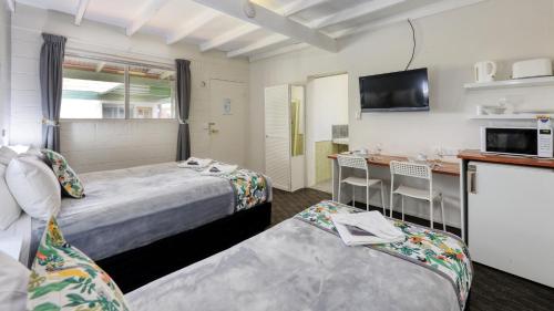 a hotel room with two beds and a kitchen at Oasis Motel in Peak Hill