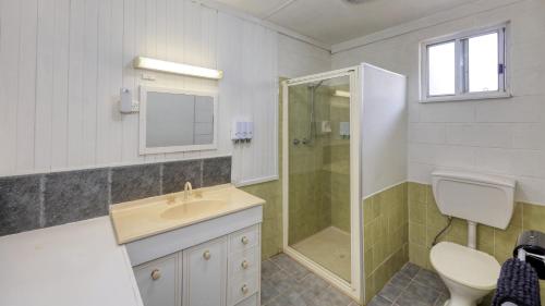 a bathroom with a sink and a shower and a toilet at Oasis Motel in Peak Hill