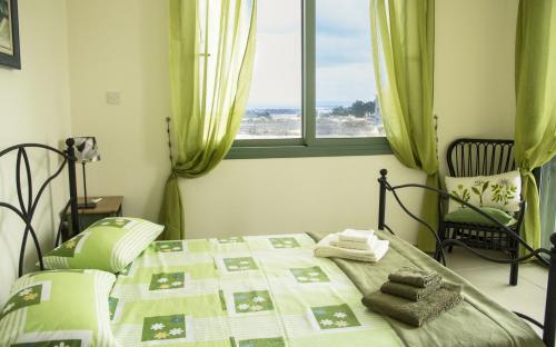 Cama en habitación con ventana y cama con toallas en Bellevue Villa en Anarita