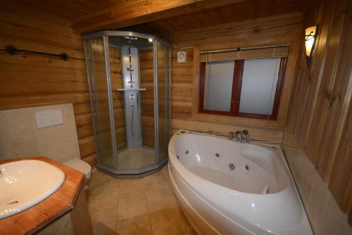 a bathroom with a tub and a toilet and a sink at Skibyen Jons Hytte in Skoro