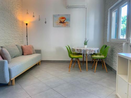 a living room with a couch and a table and chairs at Apartment Gatti Grassi in Zaboric