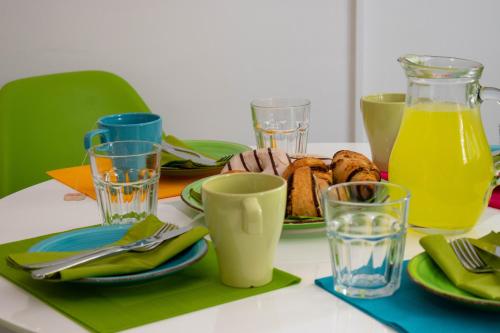 a table with a plate of food and glasses of orange juice at Apartment Gatti Grassi in Zaboric