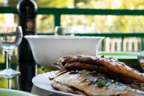 a plate of food with sausages and a glass of wine at Apartment Gatti Grassi in Zaboric